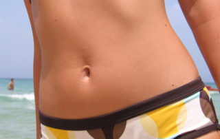 woman's waist and bikini bottoms